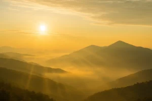 Bible Verses for Strength and Overcoming Fear - Golden sunlight breaking through soft clouds over peaceful mountain peaks at dawn, symbolizing divine strength, courage, and the peace that overcomes fear.